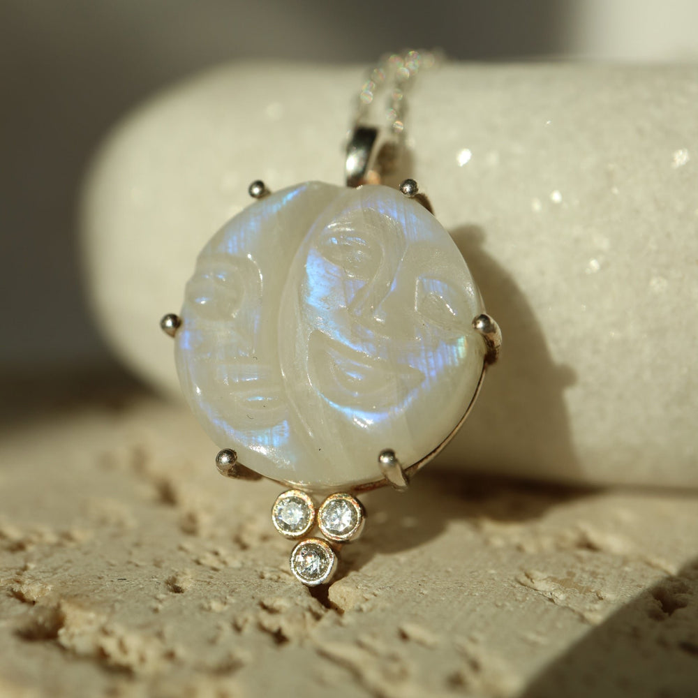 Half moon and crescent moon phases pendant necklace featuring a carved rainbow moonstone with a smiling face, set in sterling silver with cubic zirconia accents