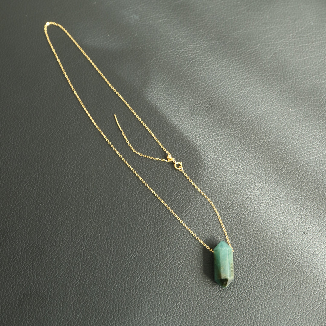 Hand-cut double-terminated emerald pendant on a 14K gold-filled chain, adjustable length. Symbolizes prosperity and abundance.